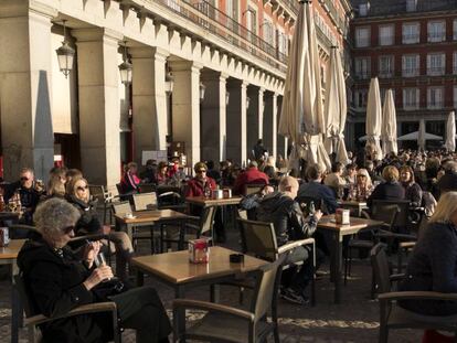 Un grupo de turistas sentados en una terraza de la Plaza Mayor, en pleno centro de Madrid. 