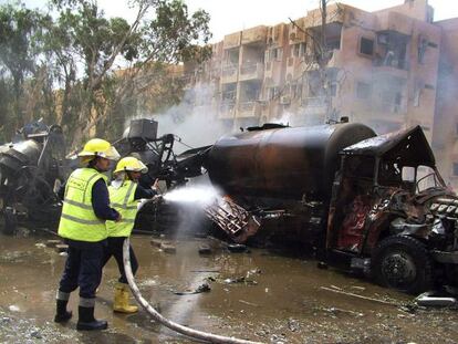 Bomberos extinguen el fuego en un camión cisterna cerca del lugar donde ha ocurrido la explosión esta mañana.