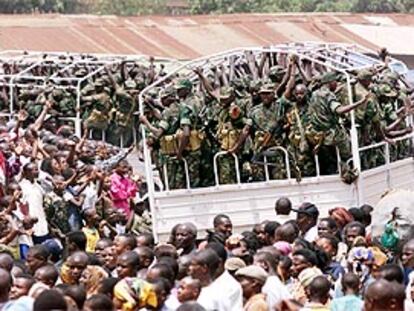 Soldados ruandeses saludan a una multitud mientras abandonan la República Democrática de Congo.