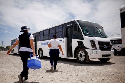 Personal sanitario camina hacia un autobús de empleados de maquilas de Ciudad Juárez para aplicarles la vacuna contra la covid-19.