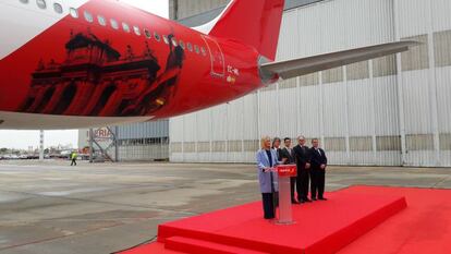 La presidenta de la Comunidad de Madrid, Cristina Cifuentes, durante el acto de presentación, esta mañana, de la ruta de Iberia que enlazará Barajas con Tokio (Japón). Detrás de ella, un Airbus A330/200 vinilado con una imagen de la puerta de Alcalá. Escuchan el discurso, el embajador de Japón en España, Masashi Mizukami, el campeón del mundo de patinaje artístico y embajador turístico de Madrid, Javier Fernández, el presidente de Iberia, Luis Gallego, y el de Aena, José Manuel Vargas.