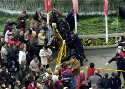 Un grupo de participantes en la manifestación intenta retirar las vallas de seguridad instaladas en la plaza de Cibeles.