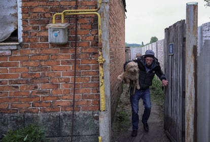 A resident flees Vovchansk after a Russian bombing, on May 14.