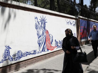 Una mujer pasa junto a una pintada antiamericana en lo que fue un muro de la Embajada de EE UU en Teherán, el pasado 16 de agosto.