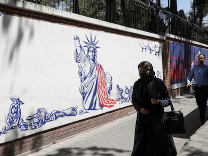 Una mujer pasa junto a una pintada antiamericana en lo que fue un muro de la Embajada de EE UU en Teherán, el pasado 16 de agosto.