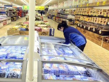 Dos empleadas reponen las neveras de un supermercado Lidl en Madrid.