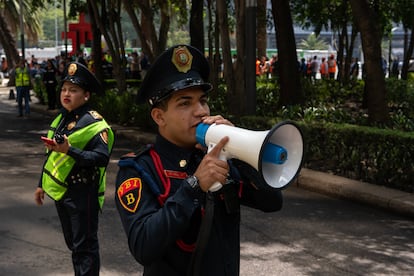 Elementos de la Policía Bancaria dirigen la evacuación de la Bolsa Mexicana de Valores en Avenida Paseo de la Reforma. 