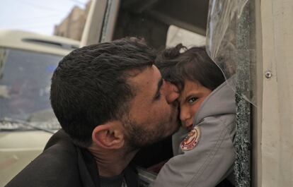 Un hombre besa a un niño durante las evacuaciones de la Media Luna Roja en Duma (Siria), el 19 de marzo de 2018.