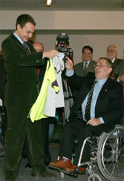 Zapatero recibe una camiseta y una sudadera del Barça durante su visita al Centro de Minusválidos de Leganés.