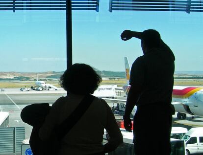Passengers look out from the airport after the accident took place. The president of the Flight JK5022 Victims Association, Pilar Vera, insists that blame cannot just be laid with the pilots, and that the Public Works Ministry and the Civil Aviation Accidents Investigation Commisssion (CIAIAC) also bear responsibility.