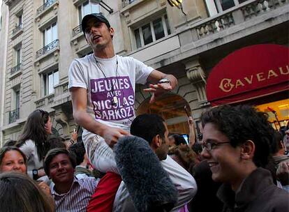 Seguidores del conservador Nicolas Sarkozy festejan, en frente de la sede del ese partido en París, que su candidato ha obtenido el primer lugar en la primera vuelta electoral por la presidencia de Francia