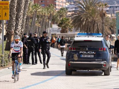 Un vehículo de la Policía Nacional junto a varios agentes en el paseo marítimo Pablo Ruiz Picasso de Málaga, el pasado mes de marzo.