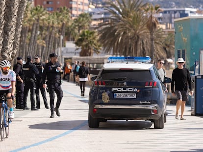 Un vehículo de la Policía Nacional junto a varios agentes en el paseo marítimo Pablo Ruiz Picasso de Málaga, el pasado mes de marzo.