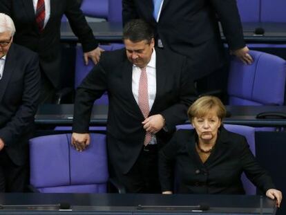 Angela Merkel no Bundestag com os titulares de Exteriores, Frank-Walter Steinmeier (esquerda), e Economia, Sigmar Gabriel.