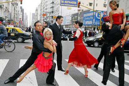 Varias parejas participantes en el Mundial de Tango bailan en una calle de Buenos Aires.
