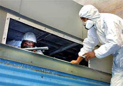 Dos técnicos de una empresa privada limpian las torres de refrigeración de la Consejería de Sanidad.