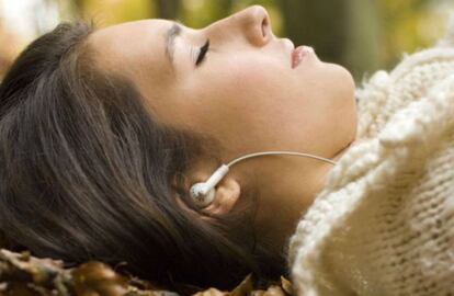 Una mujer escucha m&uacute;sica con auriculares. 