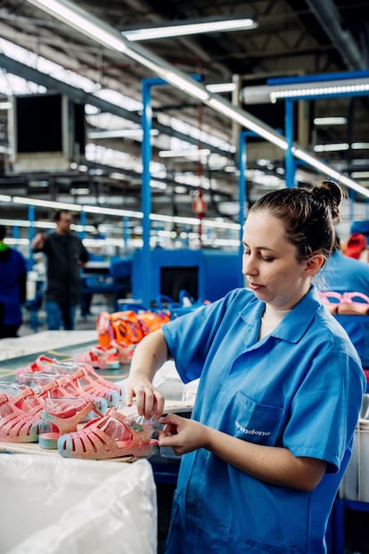 Una trabajadora, en una factoría con ejemplares del modelo Mini Melissa Possession Shiny. 