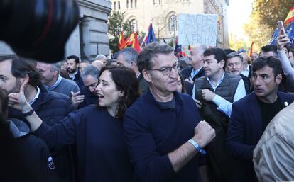 La presidenta de la Comunidad de Madrid, Isabel Díaz Ayuso, y el presidente del Partido Popular, Alberto Núñez Feijóo, saludan a los manifestantes que participan en la protesta contra la amnistía, que transcurre por el centro de Madrid. 