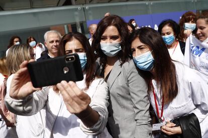 La presidenta de la Comunidad de Madrid, Isabel Díaz Ayuso se fotografía con personal sanitario en el acto de cierre del hospital de campaña del recinto ferial de Ifema.
