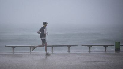 Un home corre sota la pluja a Barcelona.