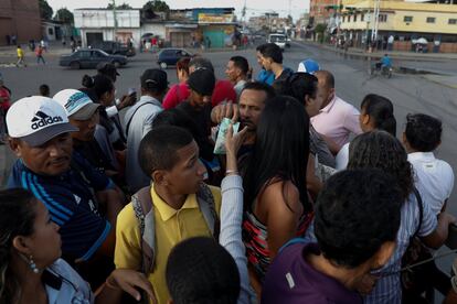 Los venezolanos se agolpan para subir a uno de estos vehículos que funcionan tanto en la capital, Caracas, como en otras grandes ciudades del país. Un pasajero paga por un billete en un camión de carga utilizado como transporte en Valencia, en el Estado de Carabobo (centro), el pasado 12 de julio.