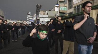 Un niño con una cinta verde, color del islam y de la oposición, participa en la marcha del Ashurá.