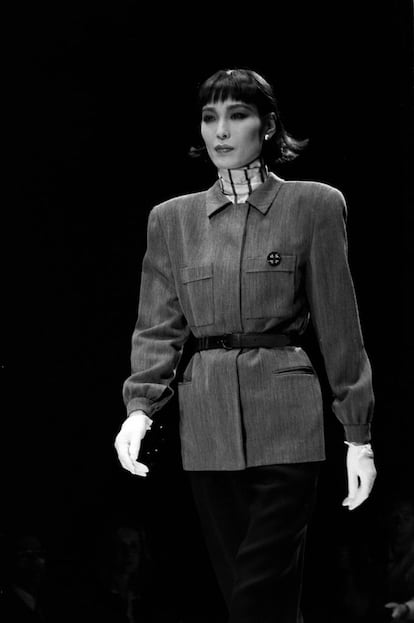 EL 'POWER DRESSING'. En una entrevista con 'S Moda' en 2022, Giorgio Armani explicaba qué le llevó a apostar en los ochenta por el traje de chaqueta femenino: “Cuando creé la silueta del traje de chaqueta femenino únicamente pensaba en cubrir sus necesidades en el lugar de trabajo. Darles comodidad y confianza en un ambiente nuevo para ellas, al que por fin accedían. No sé si eso me convierte o no en feminista. Creo que si lo soy o no deberían juzgarlo las propias mujeres”. El italiano fue el inventor de lo que posteriormente se llamó ‘power suit’: el traje, inspirado en el clásico masculino, que se convirtió en el uniforme de muchas de las mujeres que por fin accedían a puestos laborales de poder. A diferencia de otros creadores de ‘trajes poderosos’, como Claude Montana y Thierry Mugler, el traje de Armani, como el de su contraparte masculina, tenía un corte relajado y cómodo, lo que hizo que muchas mujeres, profesionales o no, se convirtieran en clientas leales durante décadas. Armani supo darles la austeridad e incluso la intelectualidad que demandaban en un momento en el que la moda iba de excesos decorativos y siluetas imposibles. En la imagen, una propuesta de su desfile de otoño-invierno de 1985.