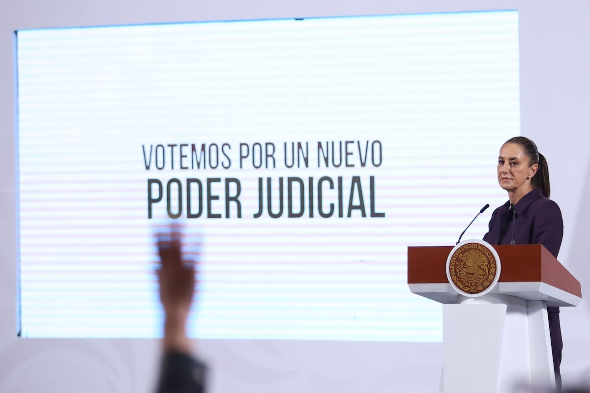 President Claudia Sheinbaum, promoting voting in new judicial elections, stands in front of a slideshow titled "Votemos por un nuevo poder judicial." 