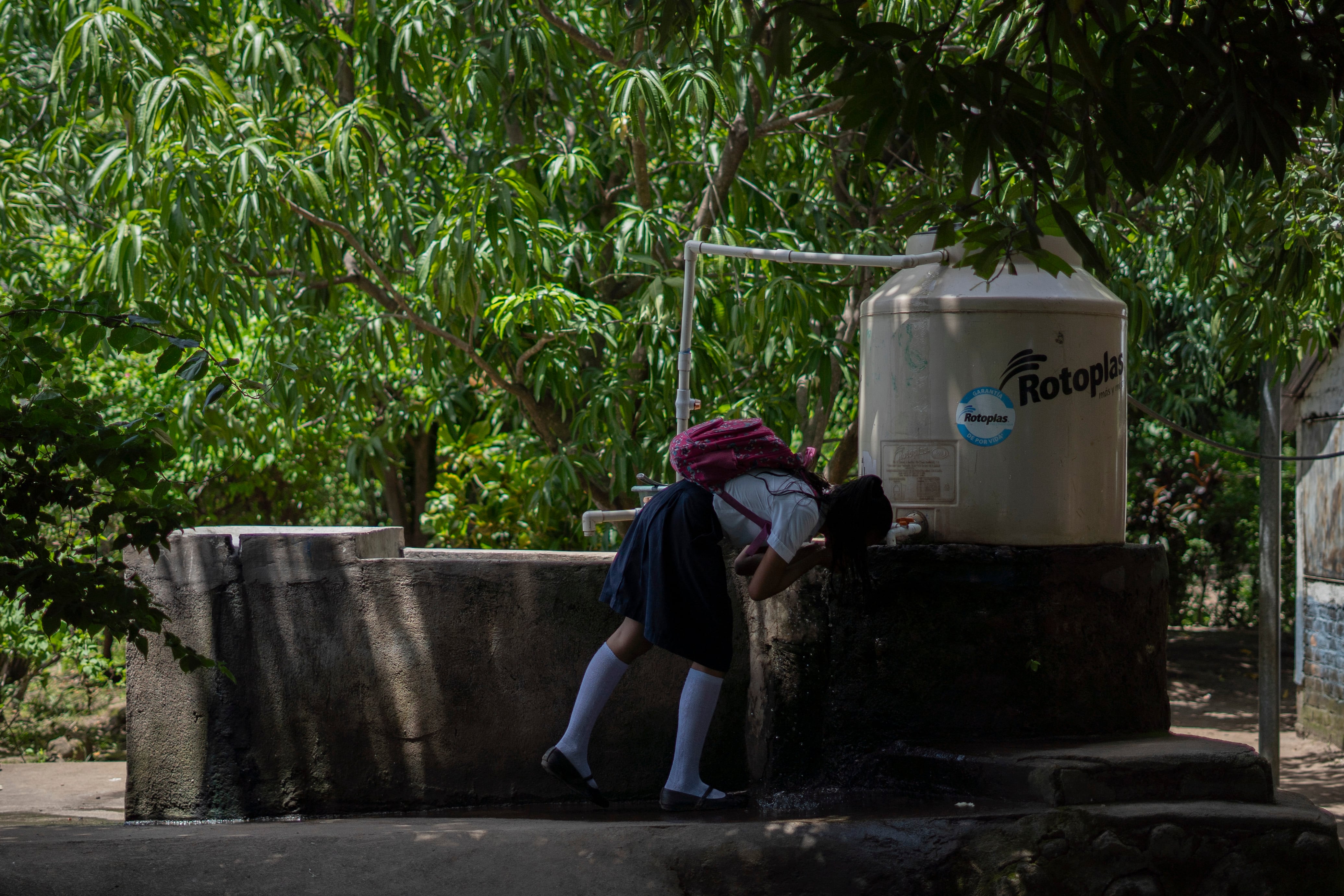 Los estudiantes beben el agua de las cisternas del centro escolar de la comunidad El Milagro.