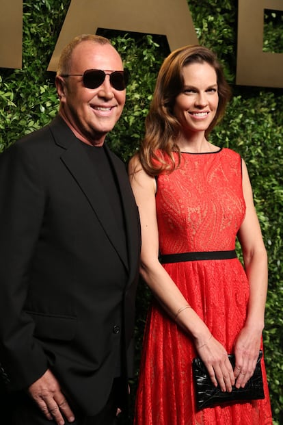 El diseñador posa junto a la actriz Hilary Swank.