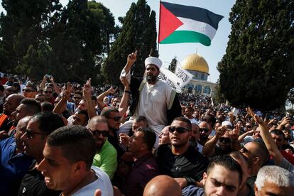 Palestinos transportan a hombros al director de la mezquita de Al-Aqsa, Shaikh Omar Kiswani, y enarbolan la bandera nacional al entrar en la Explanada de las Mezquitas, en la ciudad vieja de Jerusalén.