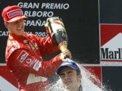 Michael Schumacher ducha con cava a Fernando Alonso en el podio.