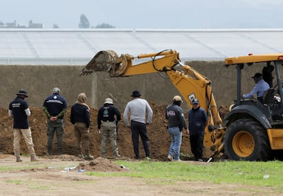 Autoridades de la Fiscalía del Estado y la Comisión Nacional de Búsqueda observan la excavación de una fosa, asistida por una grúa.