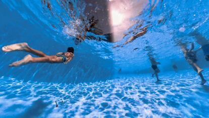 Vecinos de Teruel combaten las altas temperaturas de la tercera ola de calor refrescándose en las aguas de la piscina del poliderportivo San Fernando de la ciudad.