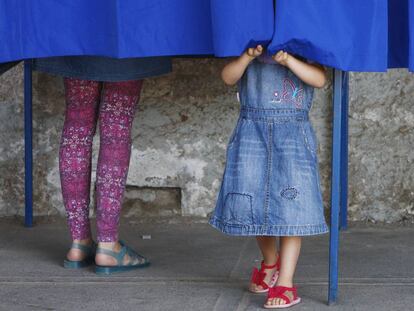 Una mujer acompa&ntilde;ada de una ni&ntilde;a vota durante la jornada de elecciones presidenciales en Chile.