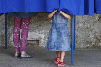 Una mujer acompa&ntilde;ada de una ni&ntilde;a vota durante la jornada de elecciones presidenciales en Chile.