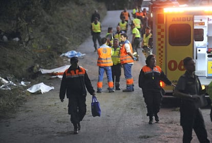 Efectivos de los servicios sanitarios de emergencias atienden a los heridos mientras los fallecidos son tapados con mantas.