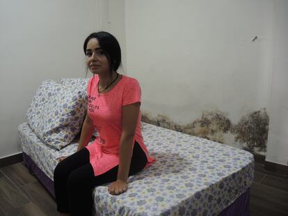 Amani Shehade en su dormitorio, junto a las humedades que han vuelto a aparecer en la pared de su casa, tras la reconstrucción.