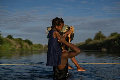 Un hombre haitiano con su hija a hombros cruza el Río Bravo entre Del Río (Texas) y Ciudad Acuña (México), el 22 de septiembre de 2021.