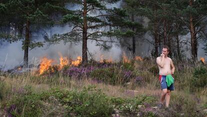 Un hombre observa el incendio forestal en A Pobra do Brolló, Lugo (Cáceres). La comunidad gallega tiene perimetrados los doce incendios que afectan a sus montes, en una jornada en la que no han crecido las 4.430 hectáreas que arden, informa la Consellería do Medio Rural este domingo.