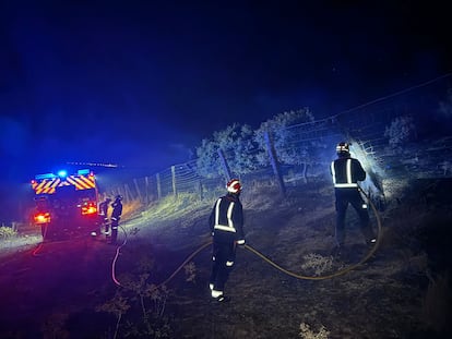 Varios bomberos, durante las labores de refresco del perímetro afectado por el incendio de Tres Cantos, la noche del jueves al viernes.