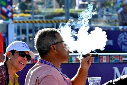 Un hombre fuma un puro en una carrera de caballos en Los Ángeles.