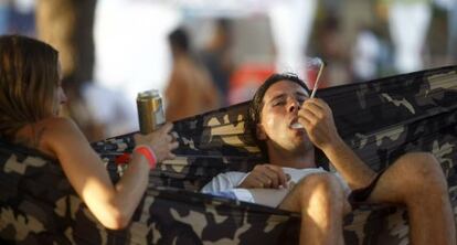 Dos asistentes al festival Rototom de Benicàssim se relajan en una hamaca.