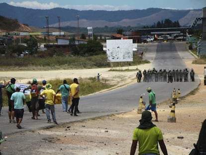 Manifestantes antichavistas frente a una barrera de guardias nacionales en la frontera entre Venezuela y Brasil. 