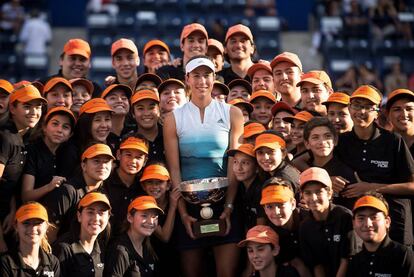 Muguruza posa con el trofeo junto a los recogepelotas de Monterrey.