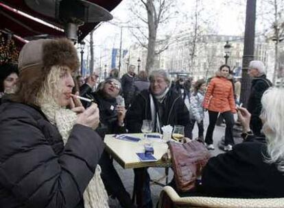 Varios turistas fuman el pasado día 1 de enero en una terraza de París.