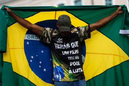 Para la mayoría de bolsonaristas, no hace falta esperar a que surjan pruebas de que la derrota de su presidente es una farsa; están convencidos. En la imagen, un seguidor de Bolsonaro sostiene una bandera brasileña durante una manifestación en Río de Janeiro. 