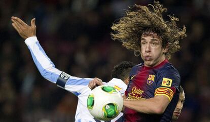 Puyol, despeja un balón ante el jugador brasileño del Málaga, Weligton.