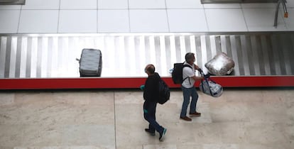 Dos pasajeros recogen su equipaje ayer, 12 de mayo, en el aeropuerto de Madrid-Barajas.